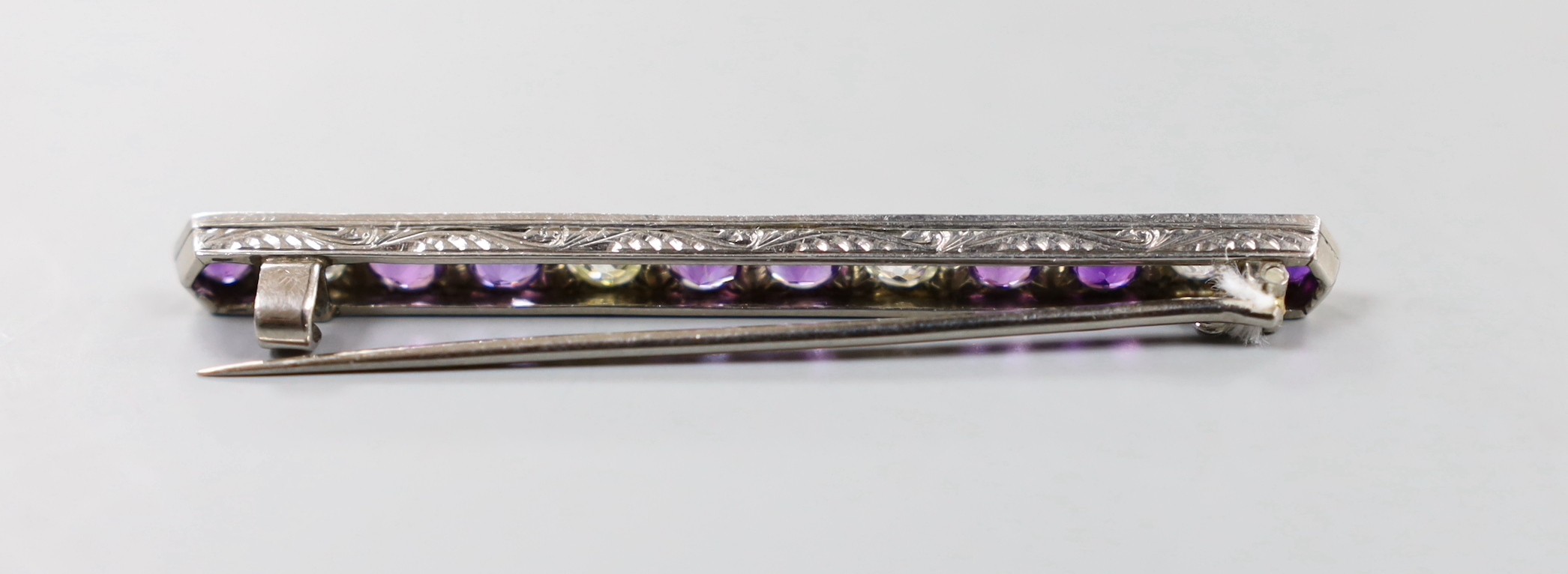 A white metal, eight stone amethyst and four stone diamond set bar brooch, 57mm, gross weight 4.6 grams.